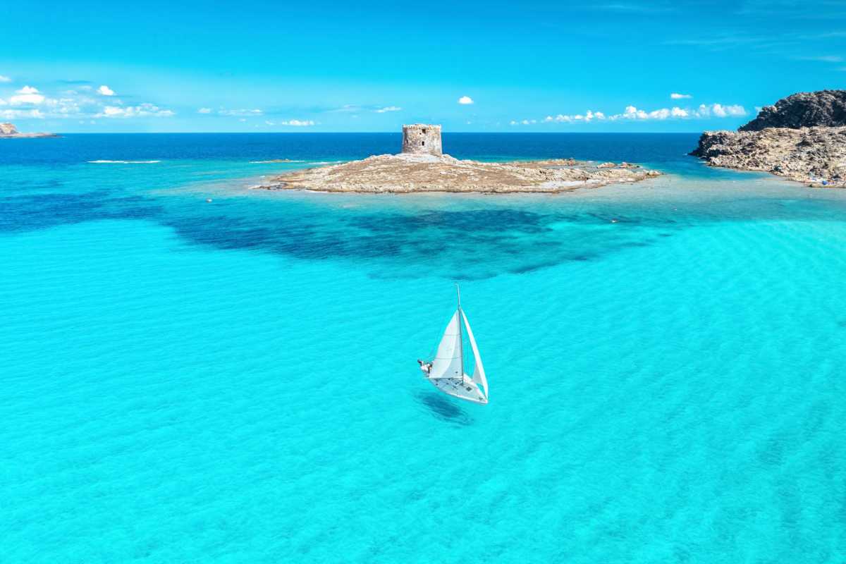 Famiglia in vacanza in un residence a Stintino, bambini che giocano in piscina, struttura immersa nel verde, atmosfera rilassata
