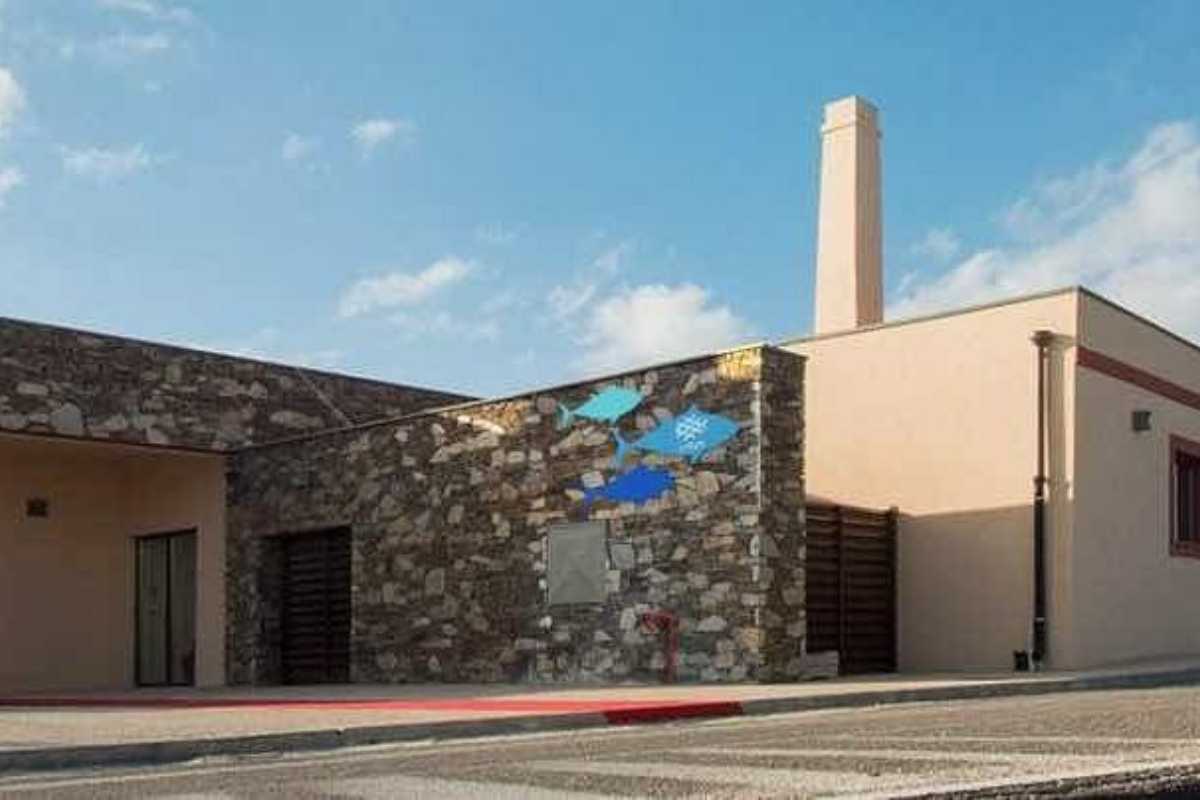 Panoramica di Stintino con scorcio del paese, Museo della Tonnara in primo piano e il mare sullo sfondo. Atmosfera rilassata, luce mediterranea.